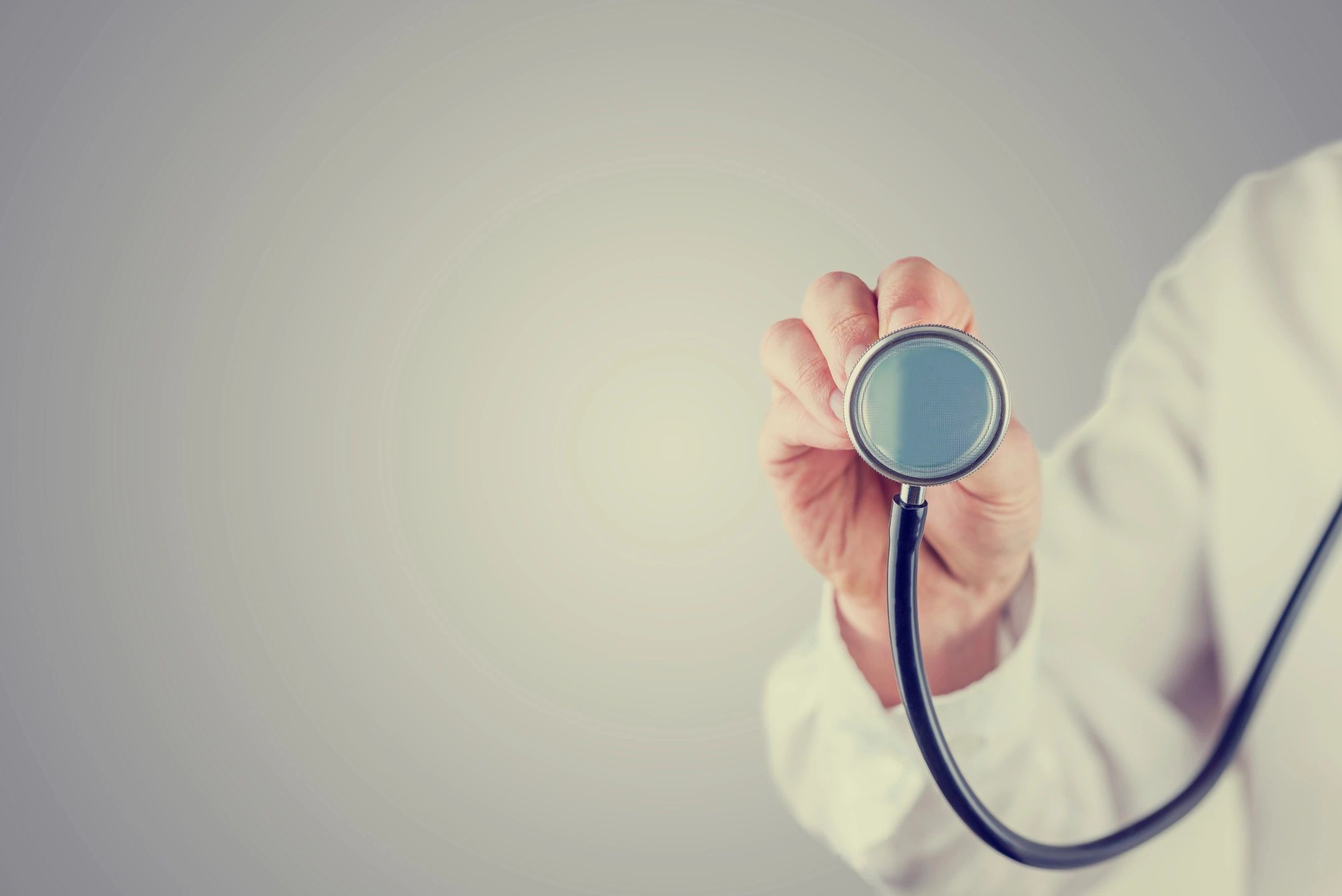 An image of a physician holding up a stethoscope.